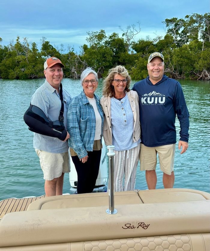 A group of friends enjoying a private boat tour near the mangroves at dusk