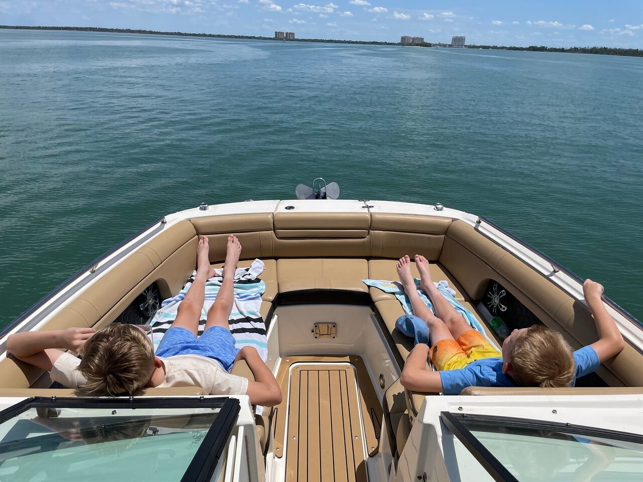 Two kids relaxing feet-up in the spacious bow seating of the Sea Ray SDX 270